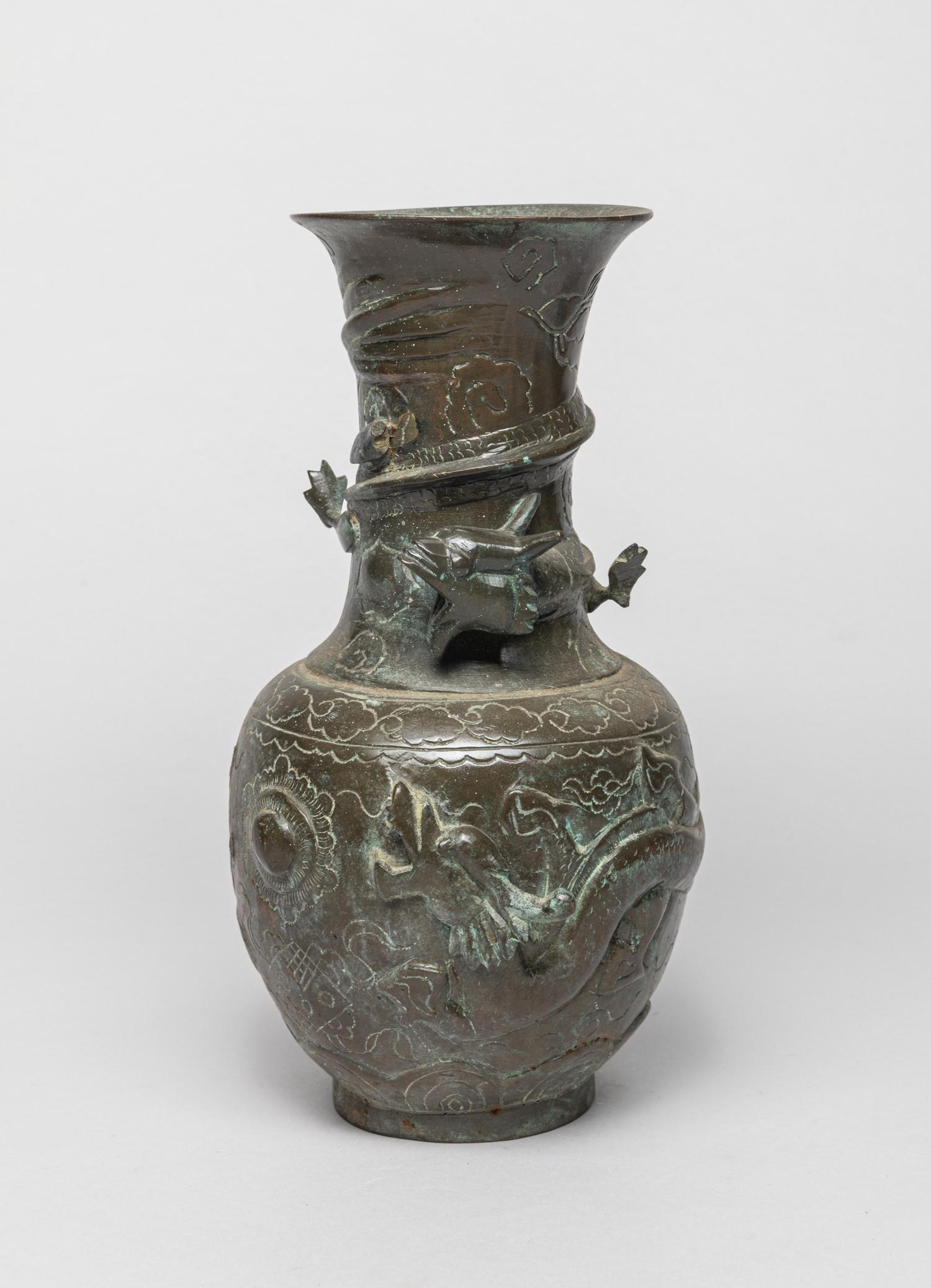 Vintage Bronze Dragon Vase: The ovoid body rising from a waisted neck and flared rim, the exterior cast in high relief with sinuous dragons coiling around the body and neck among clouds, the bottom with a Daoist mark. 9inch H, 4