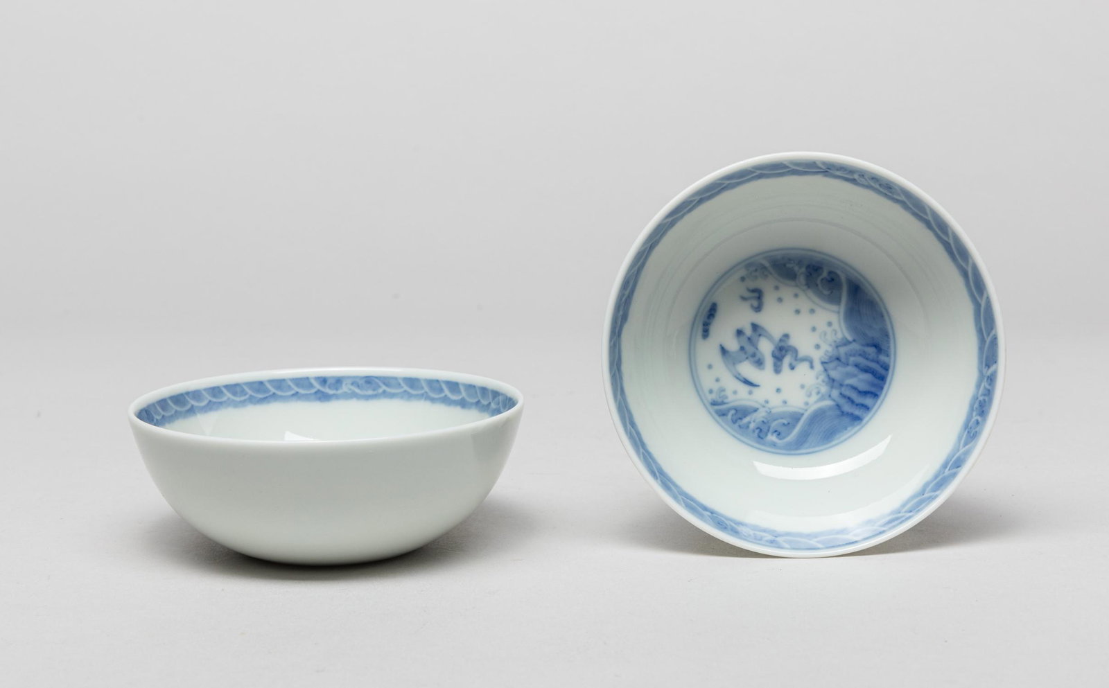 Pair Chinese Blue&White Porcelain Cups: The interior centre painted with a circular panel of a bat among clouds and above waves, the rim with a wave band. 3.7inch W, 1.4inch H (each).
