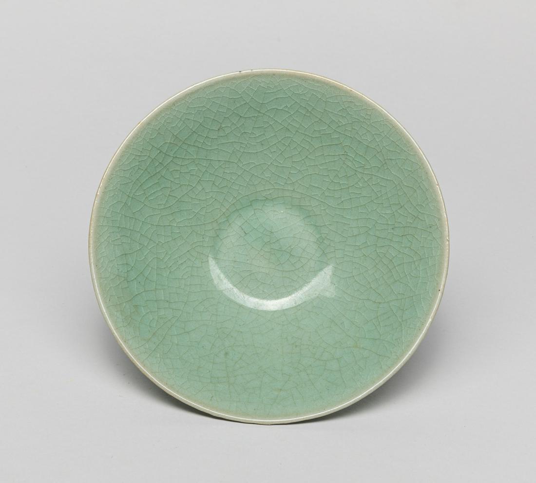 Korean Joseon Type Porcelain Lotus Bowl: The shallow sides carved around the exterior with overlapping lotus petals, covered overall in a celadon glaze suffused with a network of crackles save for the footring. 6.5inch W, 1.8inch H.