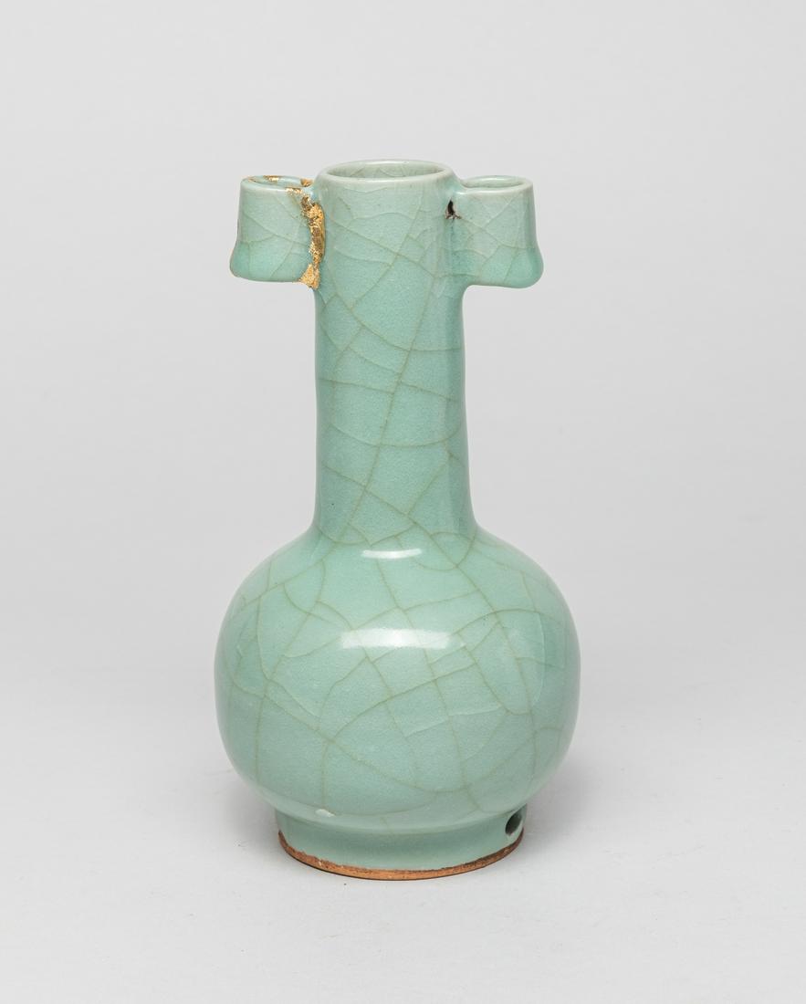 Chinese Longquan Porcelain Cabinet Vase: The globular body rising from a foot to a tall columnar neck with a pair of tubular handles, the foot pierced with two apertures, covered overall with a crackled celadon glaze stopping at the foot rin