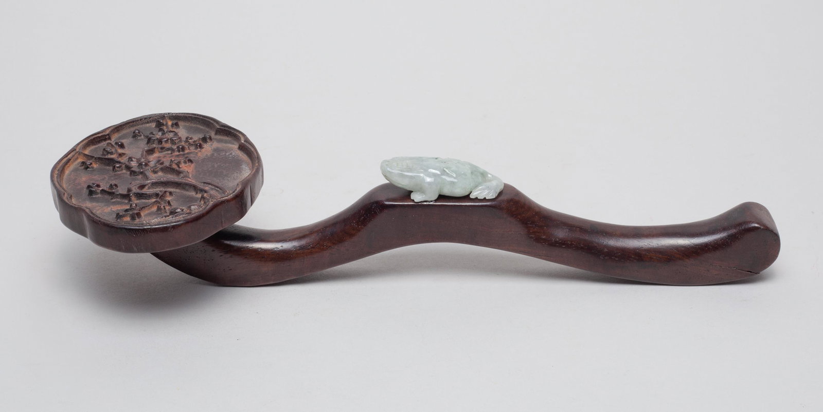 Chinese Wood Ruyi w/ Jade: The ruyi head carved in high relief with plum blossom branches, the arc shaft decorated with a recumbent jade toad. 10.4inch L, 4.1inch W, 2inch H.