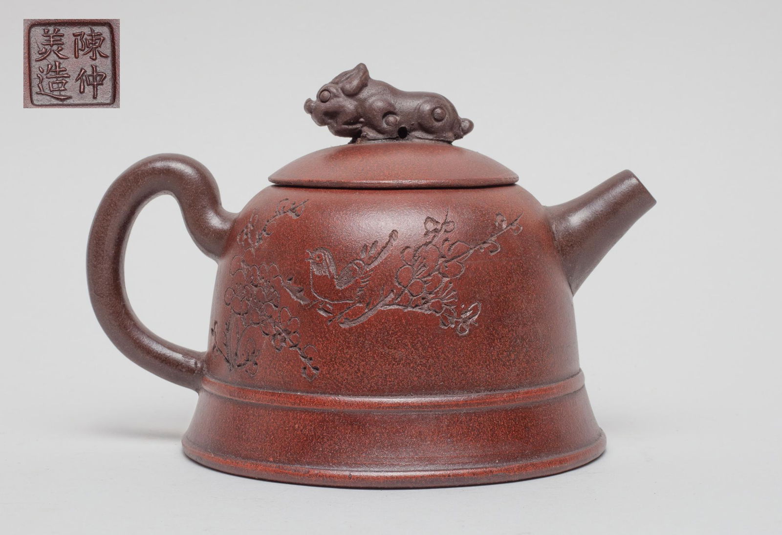 Chinese Yixing Zisha Tea Pot: Of bell form, the body carved with a bird and plum blossoms with inscription, the lid with a beast finial, the bottom carved with a seal mark. 6.2inch L, 4.7inch W, 4.2inch H.