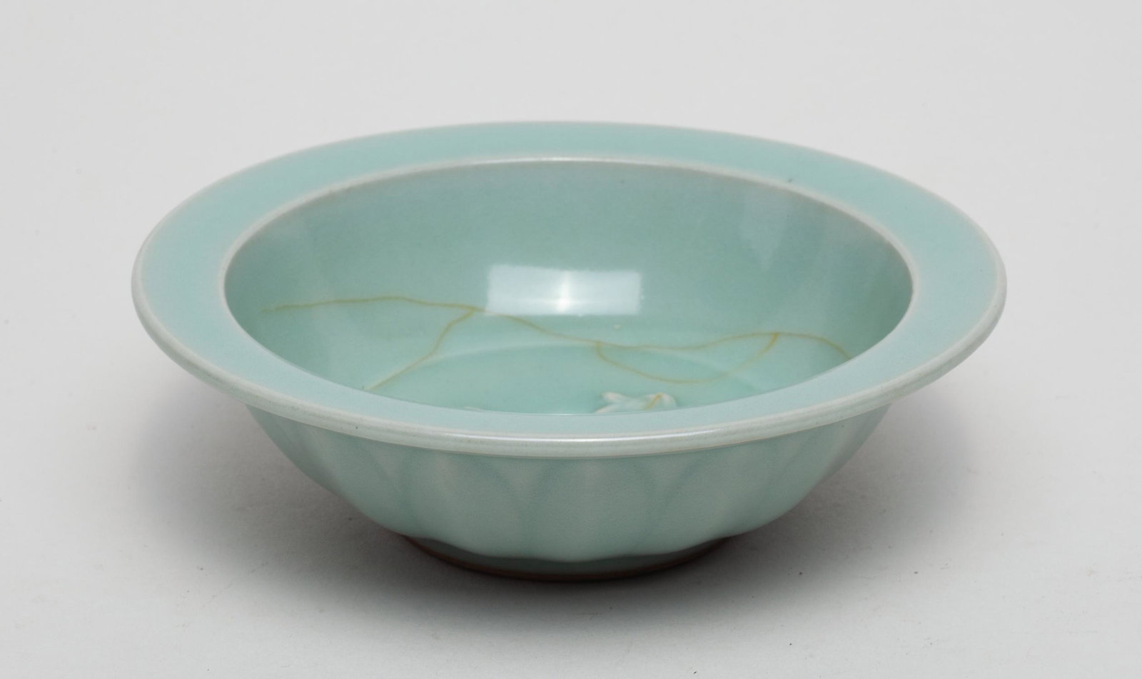 Chinese Longquan Type Porcelain Washer: The interior centre carved with a pair of carps, the exterior with a band of lotus petals, overall covered with a celadon glaze with few brown crackles. 5.3inch W, 1.6inch H.