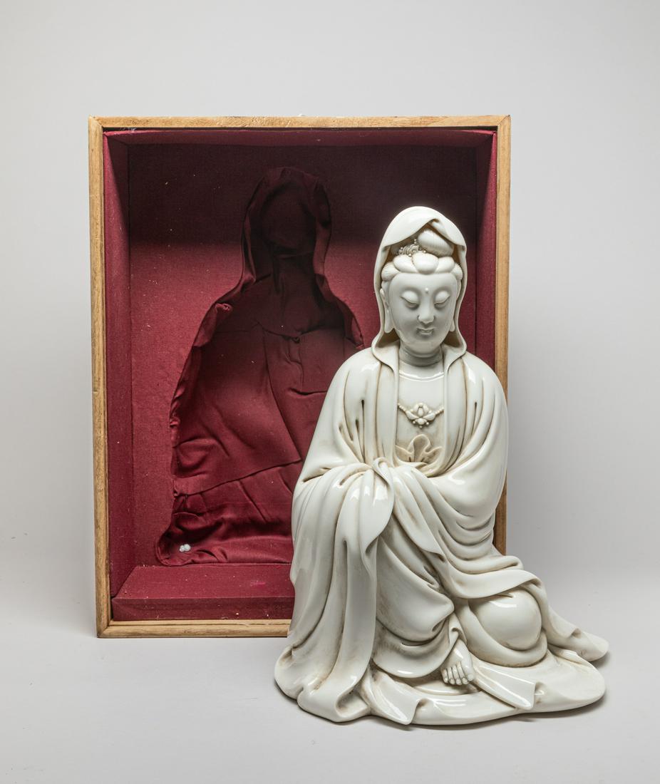 Large Chinese Blank De Porcelain Figure: Modeled as seated Kuanyin wearing a long hooded robe open at the chest to reveal a lotus necklace, one foot stretching out from the robe, the half-open eyes looking downwards, the face with gentle smi