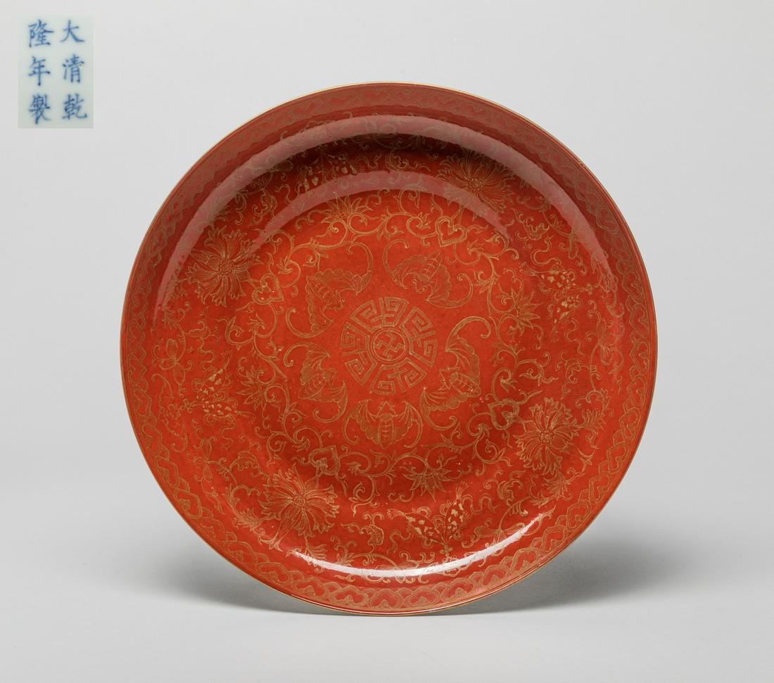 Large Chinese Famille Rose Porcelain Plate: The interior painted with bands of bats, lotus sprays or ruyi heads enclosing a central stylized symbol, all reserved on red ground, the exterior enameled with lotus sprays, the bottom marked with six