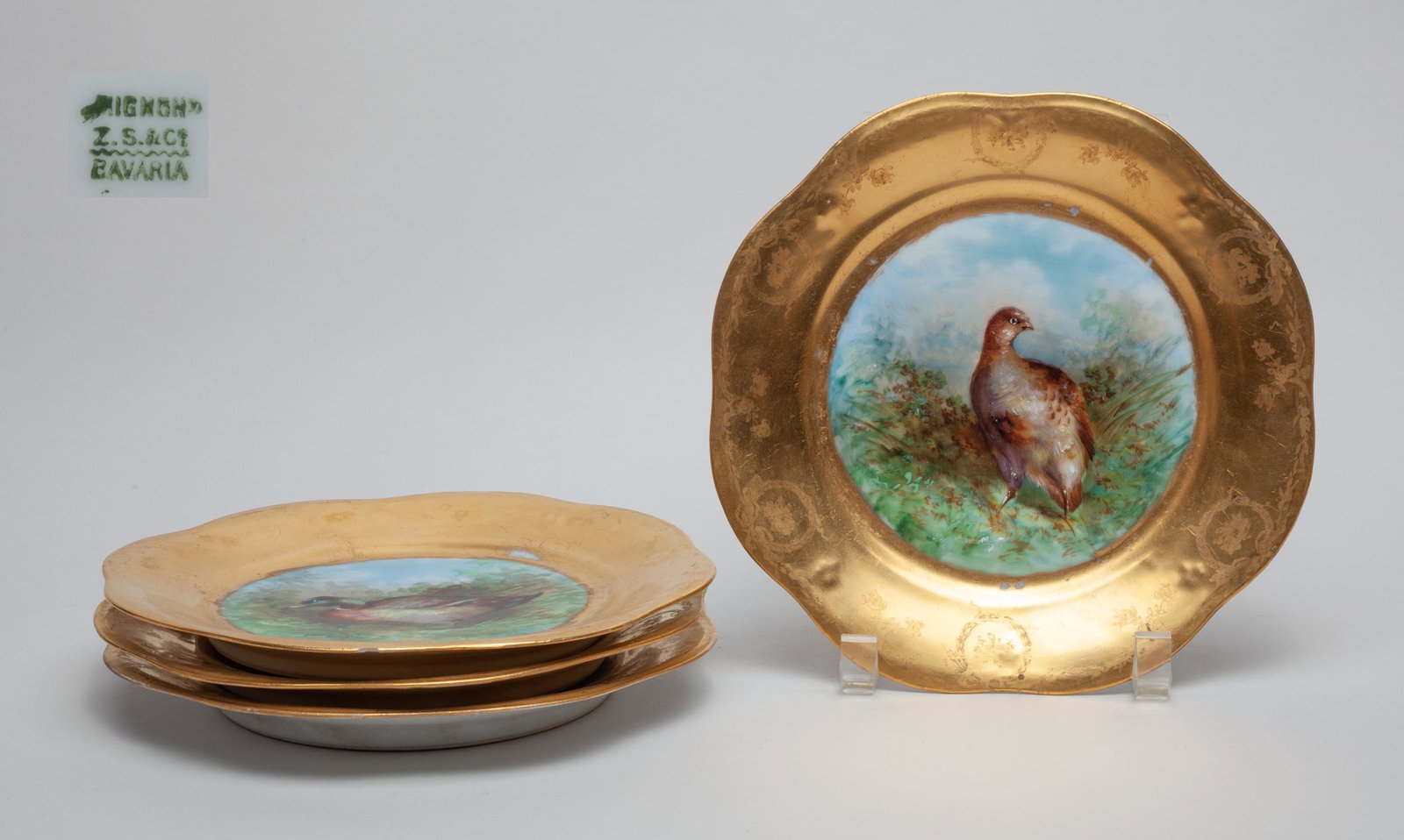 Bavaria Enameled Porcelain Plate Set: Set of four BAVARIA porcelain plates each painted the inside with a bird in field, with golden-colored rim. 8.2inch W.