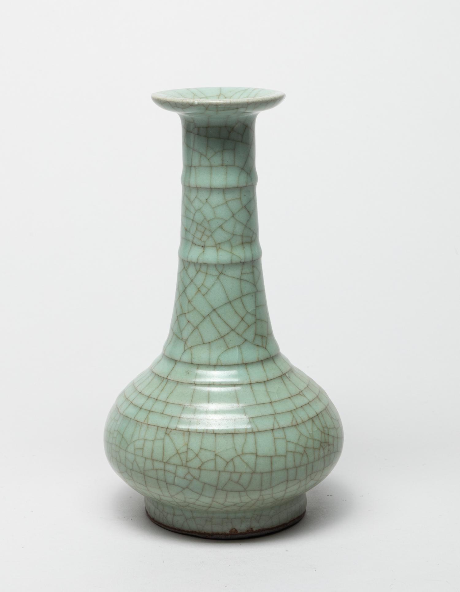 Chinese Export Porcelain Cabinet Vase: The compressed globular body rising from a short foot to a tall slender neck and flared rim, covered overall with a celadon glaze suffused with a network of brown crackles. 8.7inch H, 4.8inch W. The E