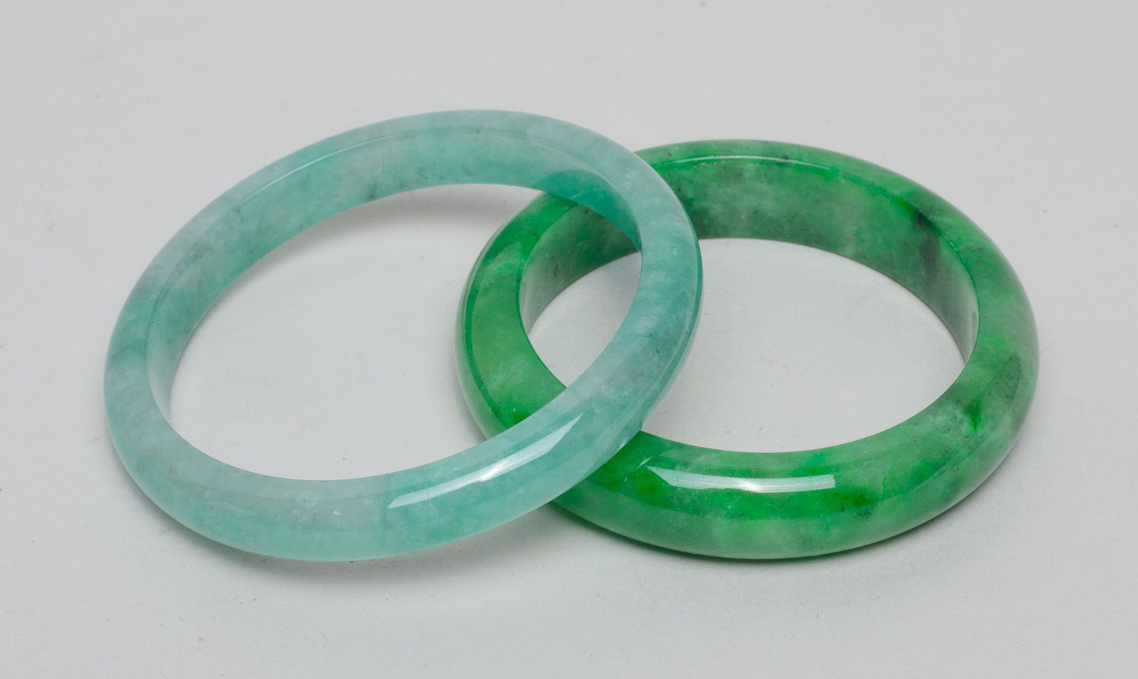 Set Chinese Bangles: Two green-color circular bangles. 2.9inch outer diameter, 2.4inch inner diameter (larger).