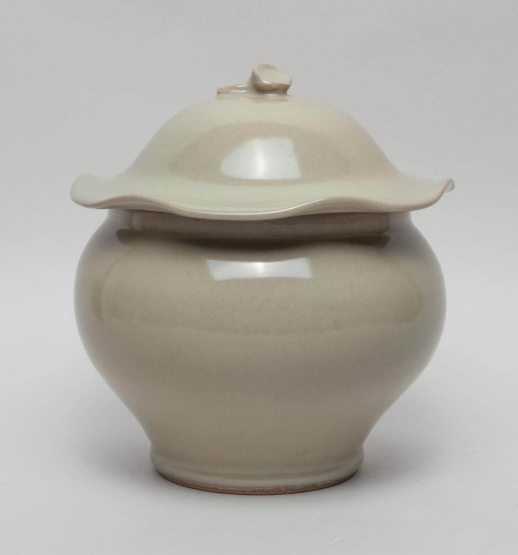 Chinese Glazed Porcelain Jar: Covered overall in beige glaze, the lotus leaf form lid set with a seedpod finial. 8inch H, 7.3inch W.