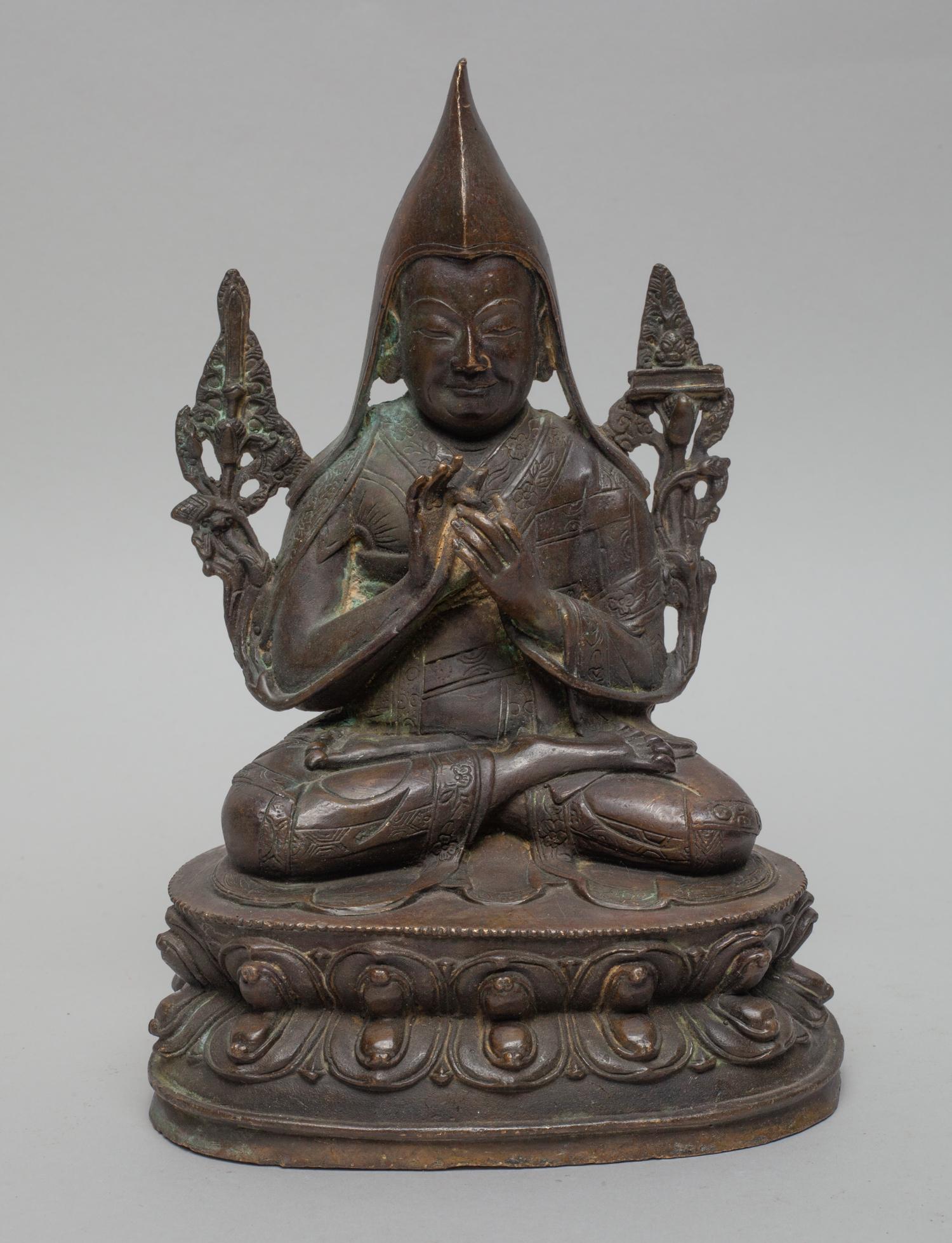 Chinese Bronze Buddha Sculpture: Cast seated in vajraparyankasana on a double lotus base, the hands in dharmachakra mudra, dressed in loose-fitting robe. 7.8inch H, 5.2inch L, 4inch W.