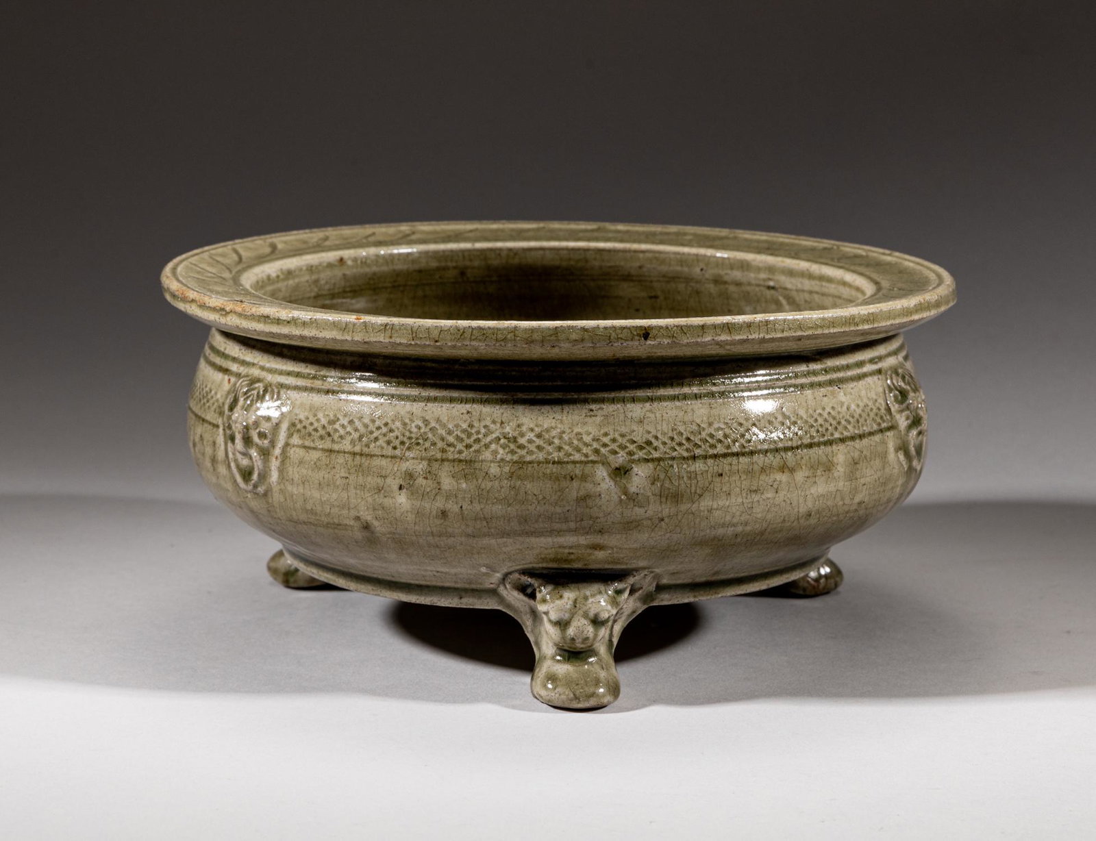Rare Chinese Yue Stoneware Porcelain Censer: Of compressed globular form, set with three beast legs and three faux-ring beast handles, covered overall in mottled olive-green glaze suffused natural crackles. Approx. 9-4 inch.