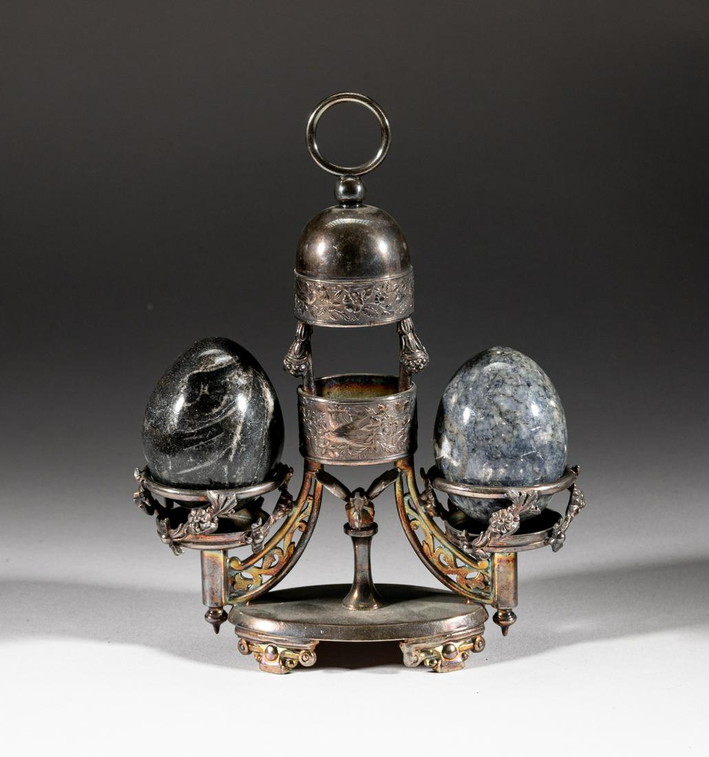 Silver-plated Table Ware w/ Fossil Eggs: Two collectible fossil stone carved eggs, supported on silver-plated stand, the bottom marked Rogers Smith Co. Meriden. Approx. 2.3-1.9 inch (larger egg size).