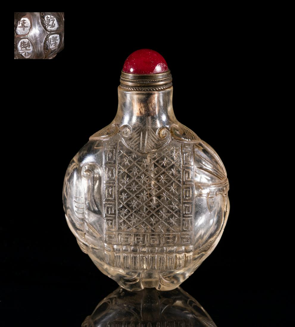 Chinese Clear Peiking Glass Snuff Bottle: The clear glass snuff bottle of rounded shape carved in elephant form,inscribed with four characters on the feet, with stopper. Approx. 2.9-2-1.1 inch.
