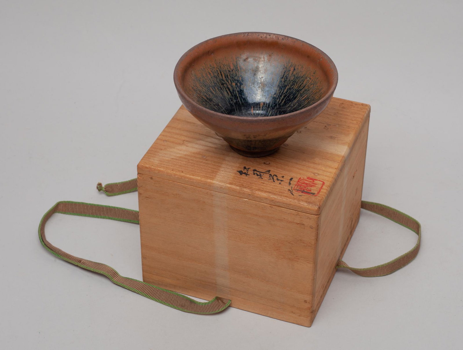 Chinese Jian Stoneware Porcelain Bowl: Of conical form, covered the inside and out in black glaze suffused with brown streaks, with box. Approx. 4.7-2.5 inch.