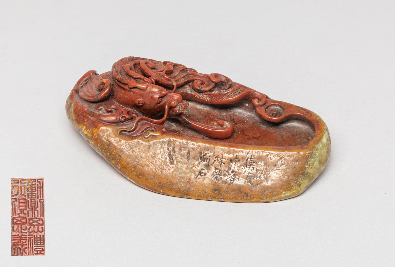 Large Chinese Shoushan Stone Washer: The russet stone washer carved with a ferocious dragon among waves and spraying water, inscribed with eight characters, the underside carved with eight characters. Approx. 6.7-3.9-1.9 inch.