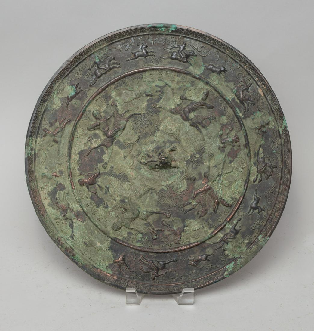 Massive Chinese Bronze Mirror: Cast with figures riding on horses and chasing beasts. Approx. 14.2inch W.