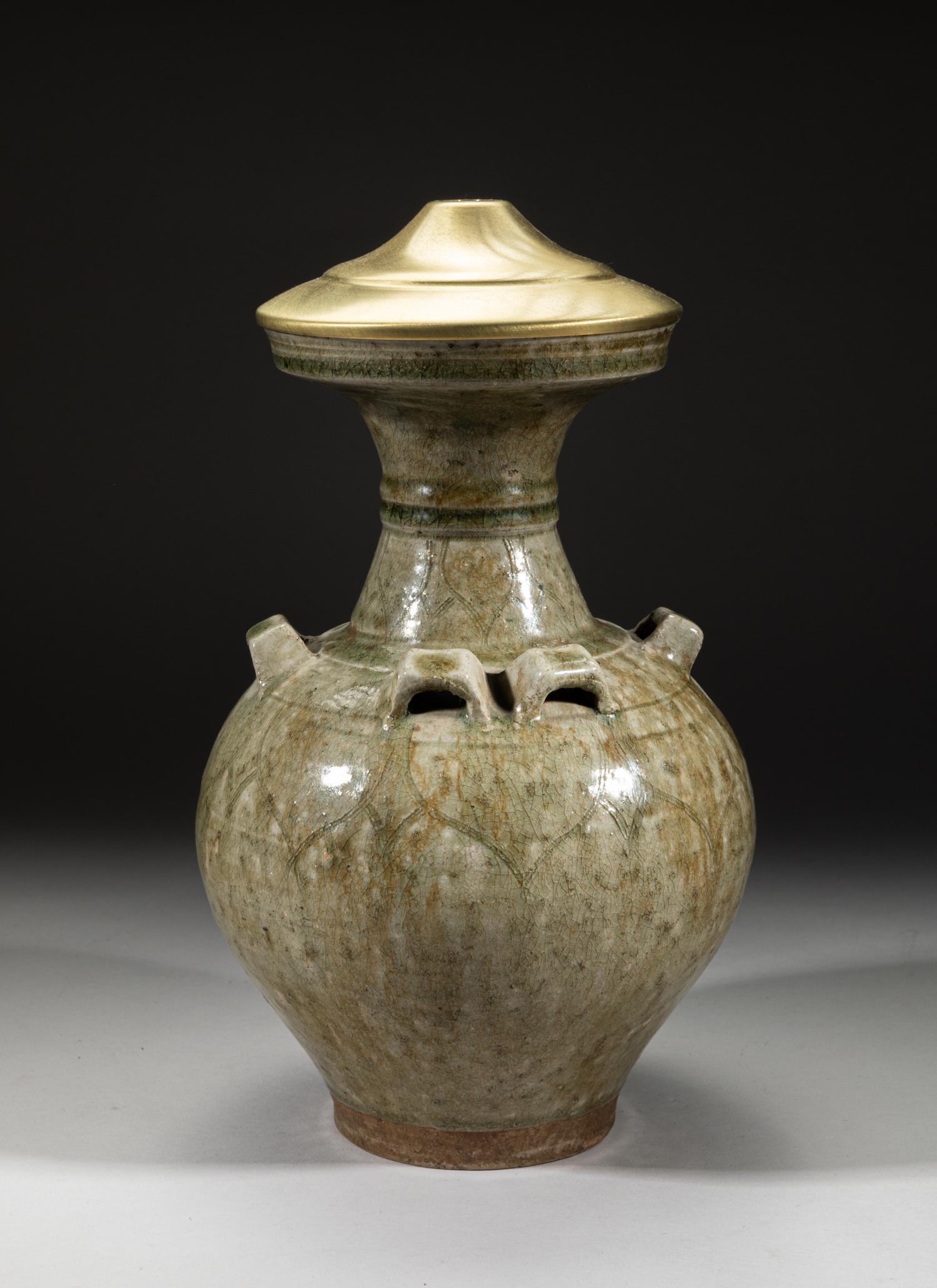 Chinese Yue Type Porcelain Vase: The tapered body rising to a waisted neck, set at the shoulder with raised handles, carved in low relief with lotus petals, applied overall save for the foot in crackled celadon glaze, the mouth stuck