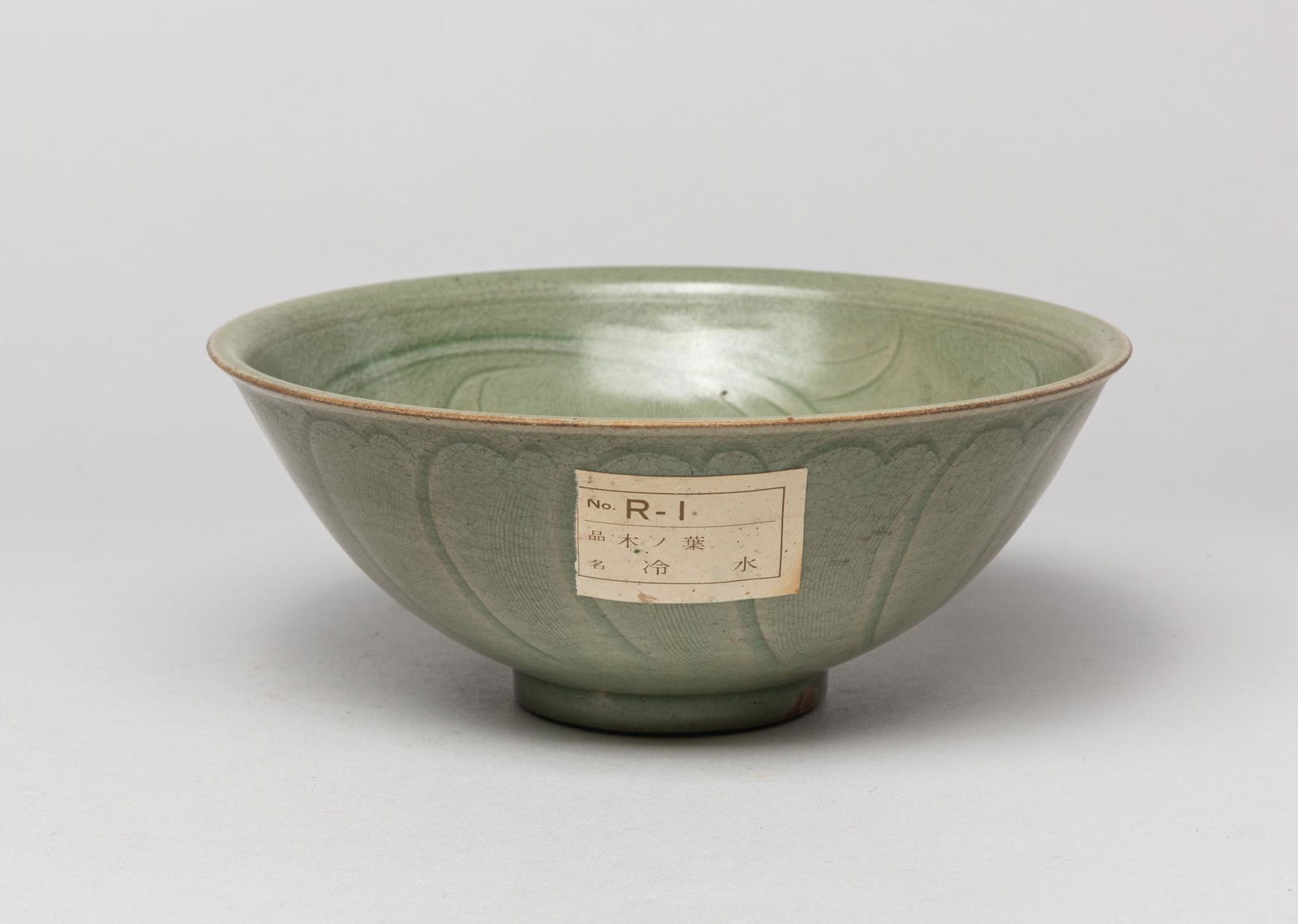 Chinese Shipwreck Porcelain Lg Bowl: The interior carved in low relief with large flowers, the exterior with overlapping petals, covered overall in crackled celadon glaze, stopping at the unglazed foot. Approx. 6.8-2.7 inch. The Estate o