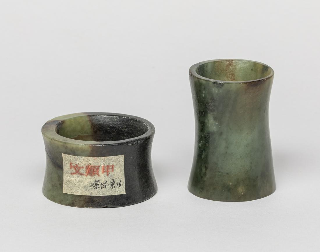 Estate Chinese Jade Carvings of Gu: Two Chinese jade gu, of waisted columnar form, the stone of a variegated green and black color. Approx. 2.6-1.8 inch (larger).