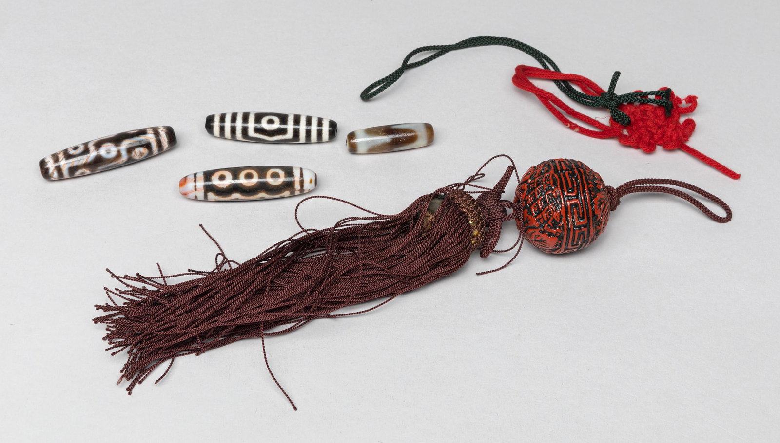 Chinese Sino-Tibetan Beads: Including a large clay bead with tassel, and 4 Sino-Tibetan agate beads. Approx. 2.25inch L (agate bead size),