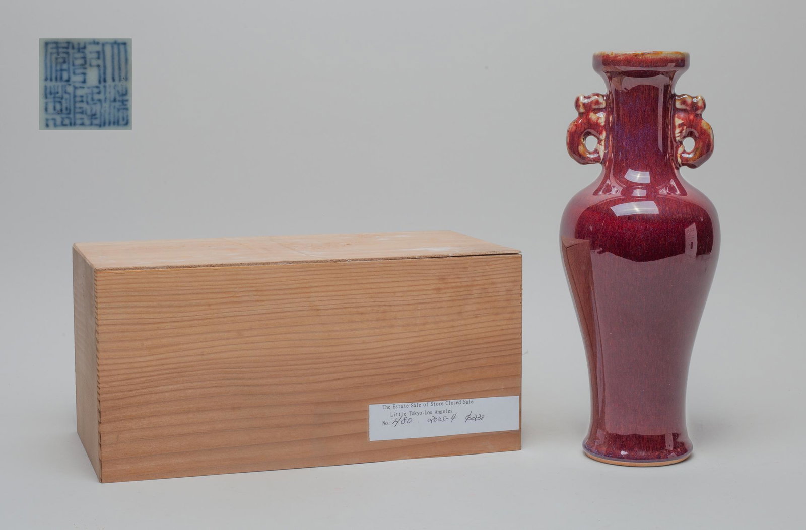 Chinese Red Glazed Porcelain Vase: the baluster body rising from spreading foot to cylindrical neck with two beast handles, covered the exterior in rick streaked red glaze, the bottom with six-character mark, with lidless box. Approx. 