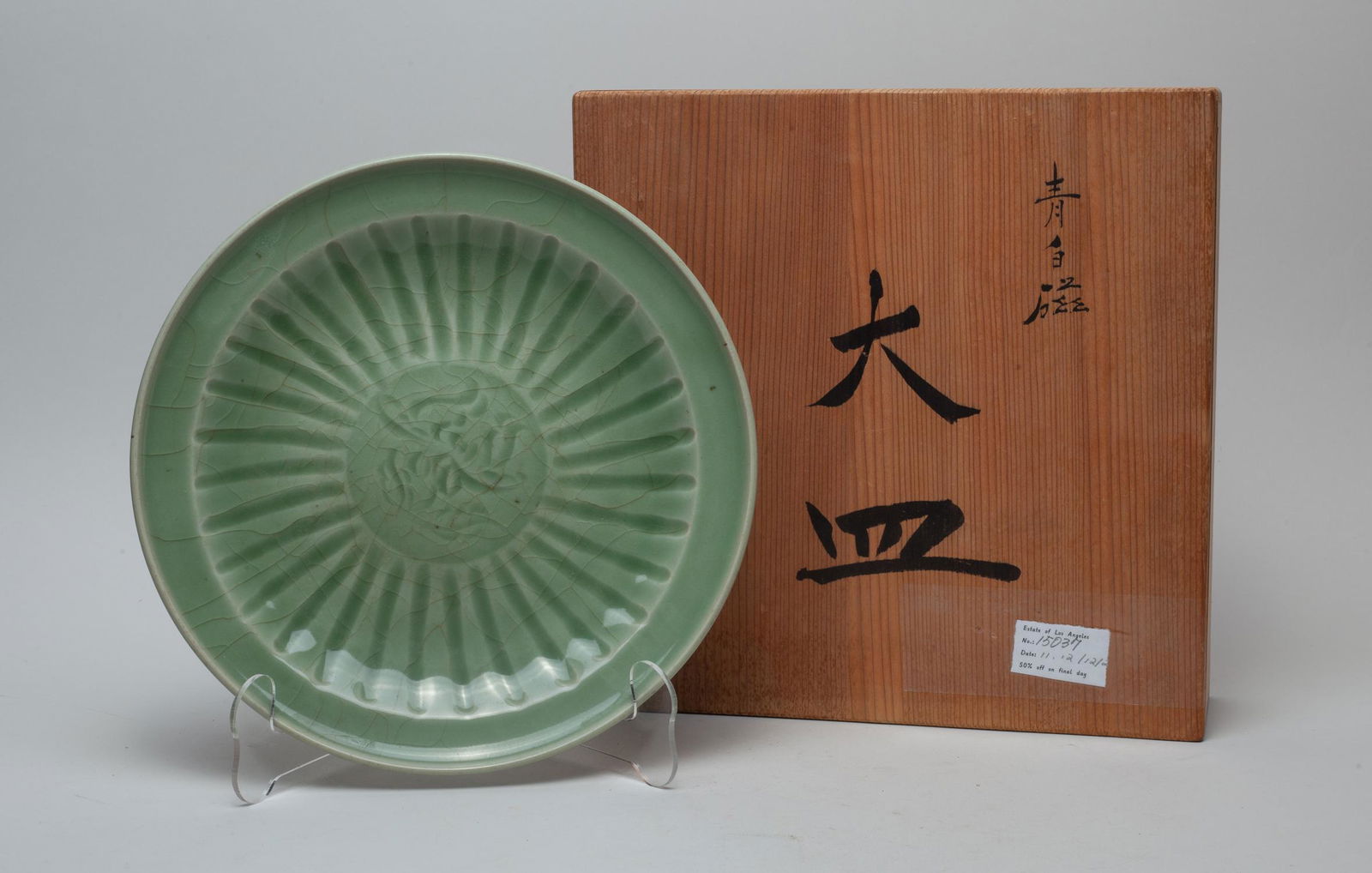 Estate Chinese Longquan Porcelain Charger: The interior centre carved in low relief with lotus, surrounded by a band of petals, covered overall save for the bottom in crackled celadon glaze, with box. Approx. 10inch W.