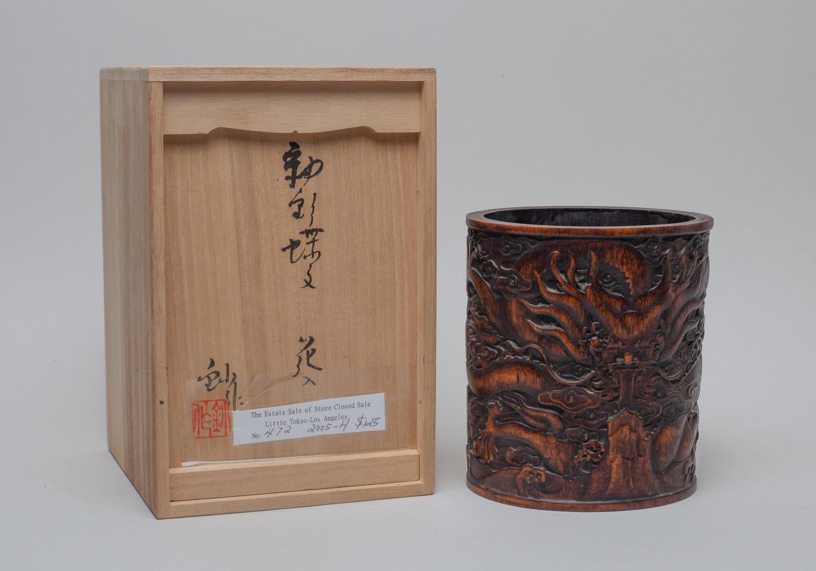 Chinese Carved Bamboo Brush Pot: The brush pot exterior carved with a ferocious dragon among clouds above waves, with box. Approx. 5.7-5.1-4.5 inch. The Estate of Japanese Store Closed Sale.
