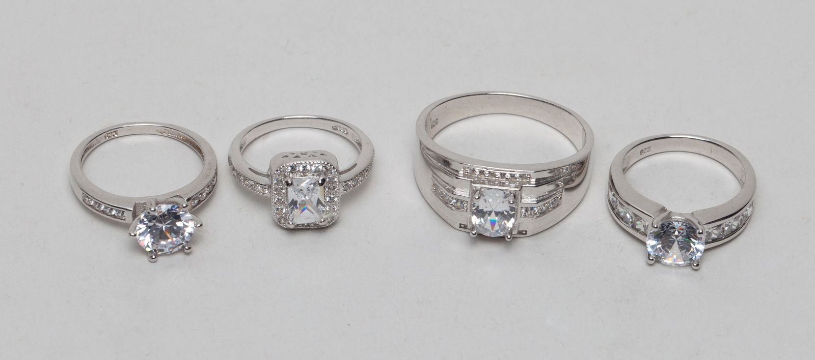 Sterling Silver Ring Inlaid Simulated Diamond: Group of 4 sterling silver rings inlaid with simulated diamond, each marked 925. Approx. 17 gram (total weight).