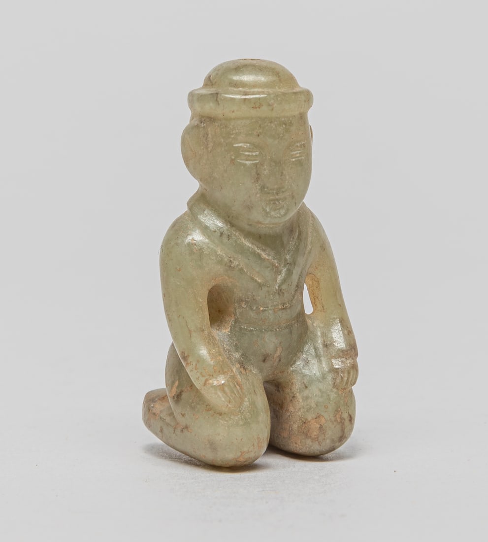 Chinese Jade Carved Figure: Chinese jade carved figure kneeling on his knees, the stone in pale celadon tone with brown inclusions. Approx. 1.8-0.9-0.8 inch.