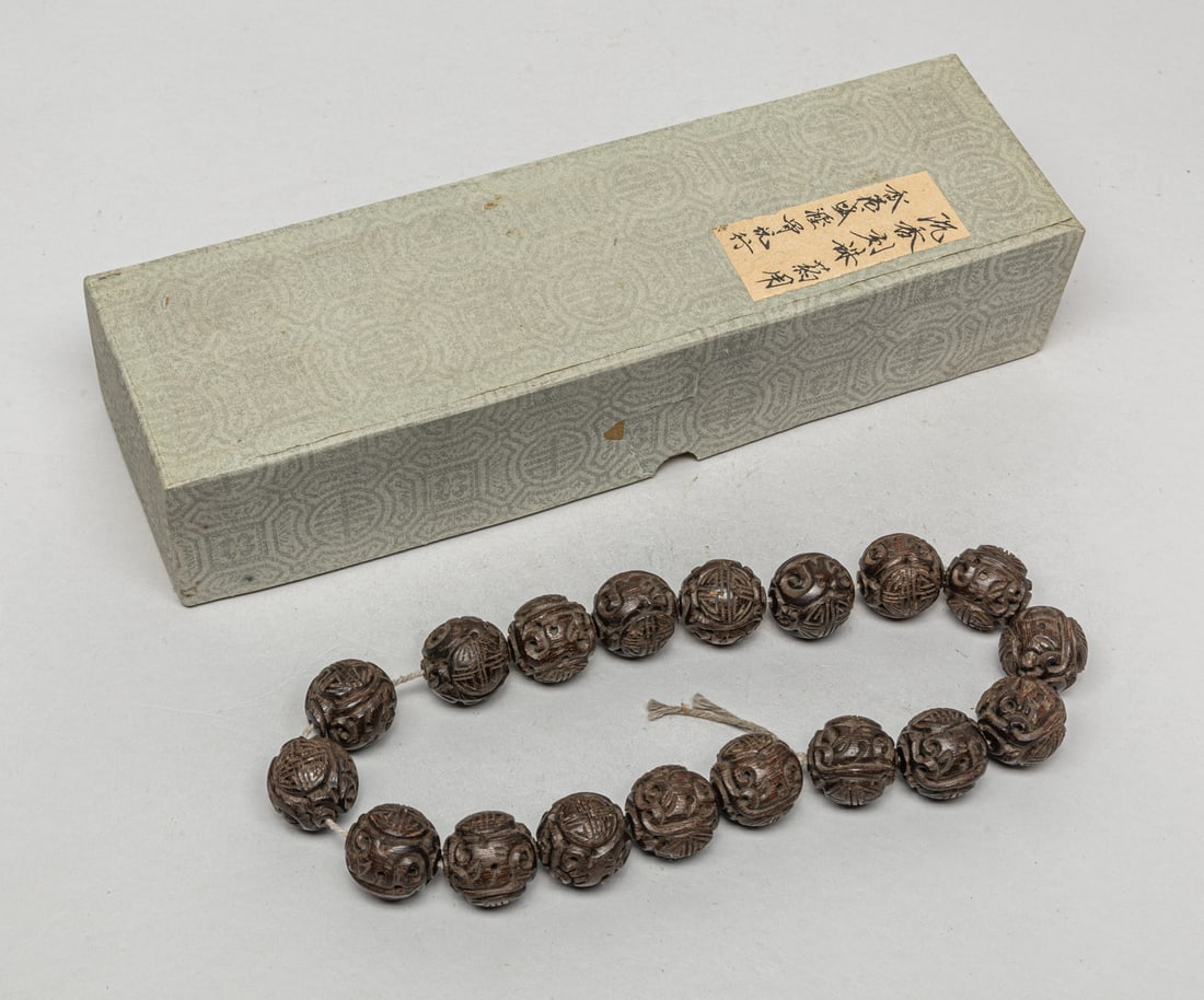 Large Bead Chinese Agarwood Beads: Group of 18 large Chinese agarwood beads carved with bats and stylized shou characters. Approx. 98 gram (total weight).