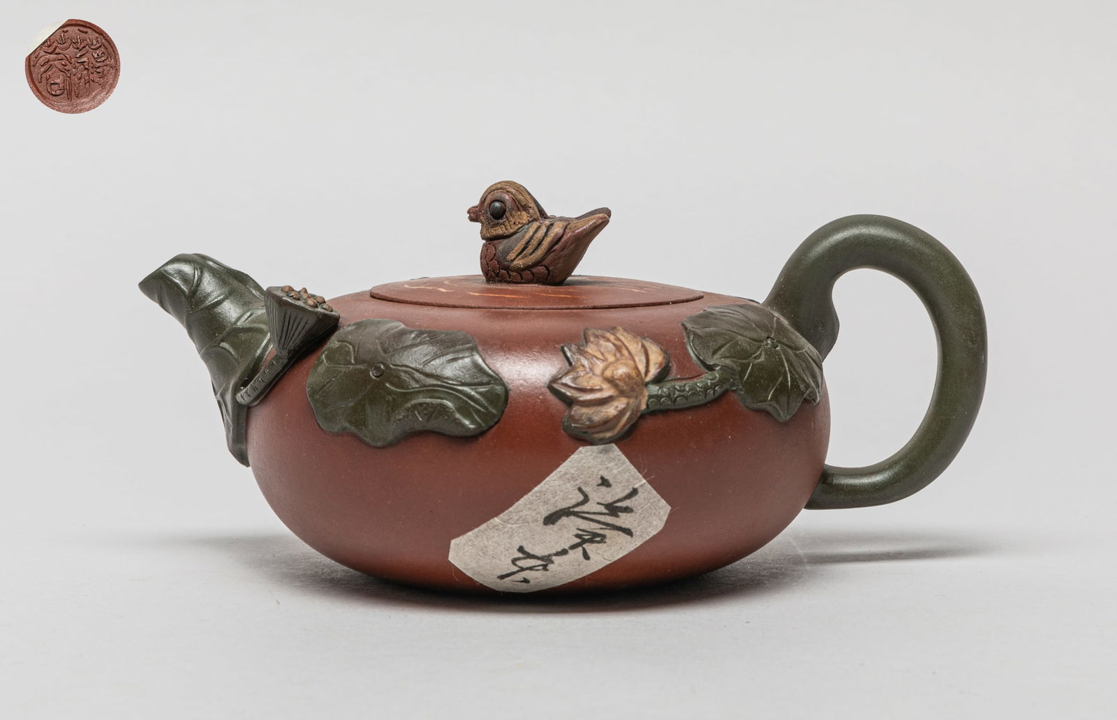 Estate Chinese Yixing Zisha Tea Pot: The body carved in raised relief with lotus, the lid set with twin bird finial and carved with a mark on the inside, the bottom carved with circular mark. Approx. 6.7-4.6-3.1 inch.