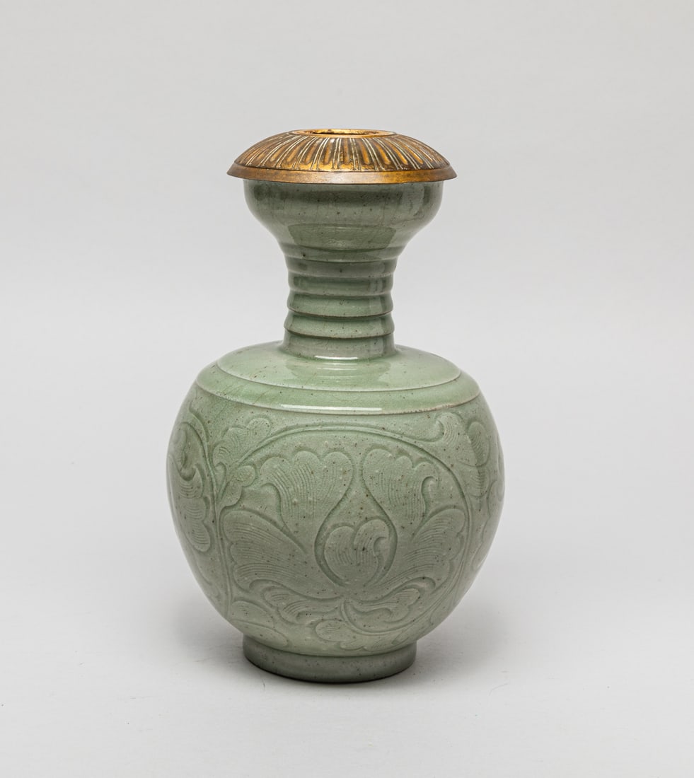 Chinese Yaozhou Porcelain Fireplace Vase: The body carved in low relief with large blooms borne on leafy stem, covered in crackled celadon green glaze, the mouth set with metal cover. Approx. 9-5.5 inch.