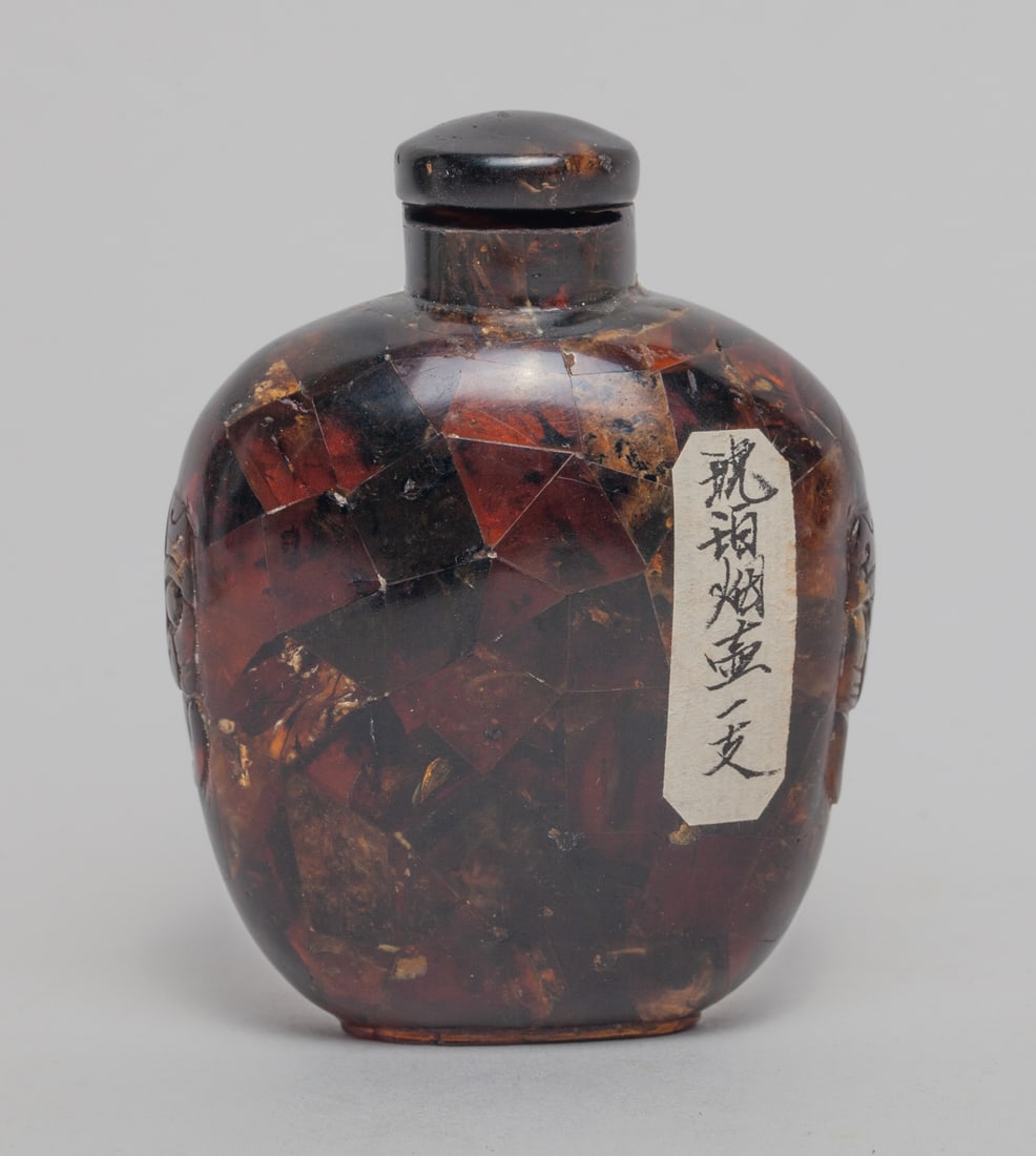 Chinese Amber Snuff Bottle: Chinese amber snuff bottle of ovoid form, carved with a pair of faux-ring beast mask handles, with a stopper. Approx. 3.2-2.4-1.4 inch.