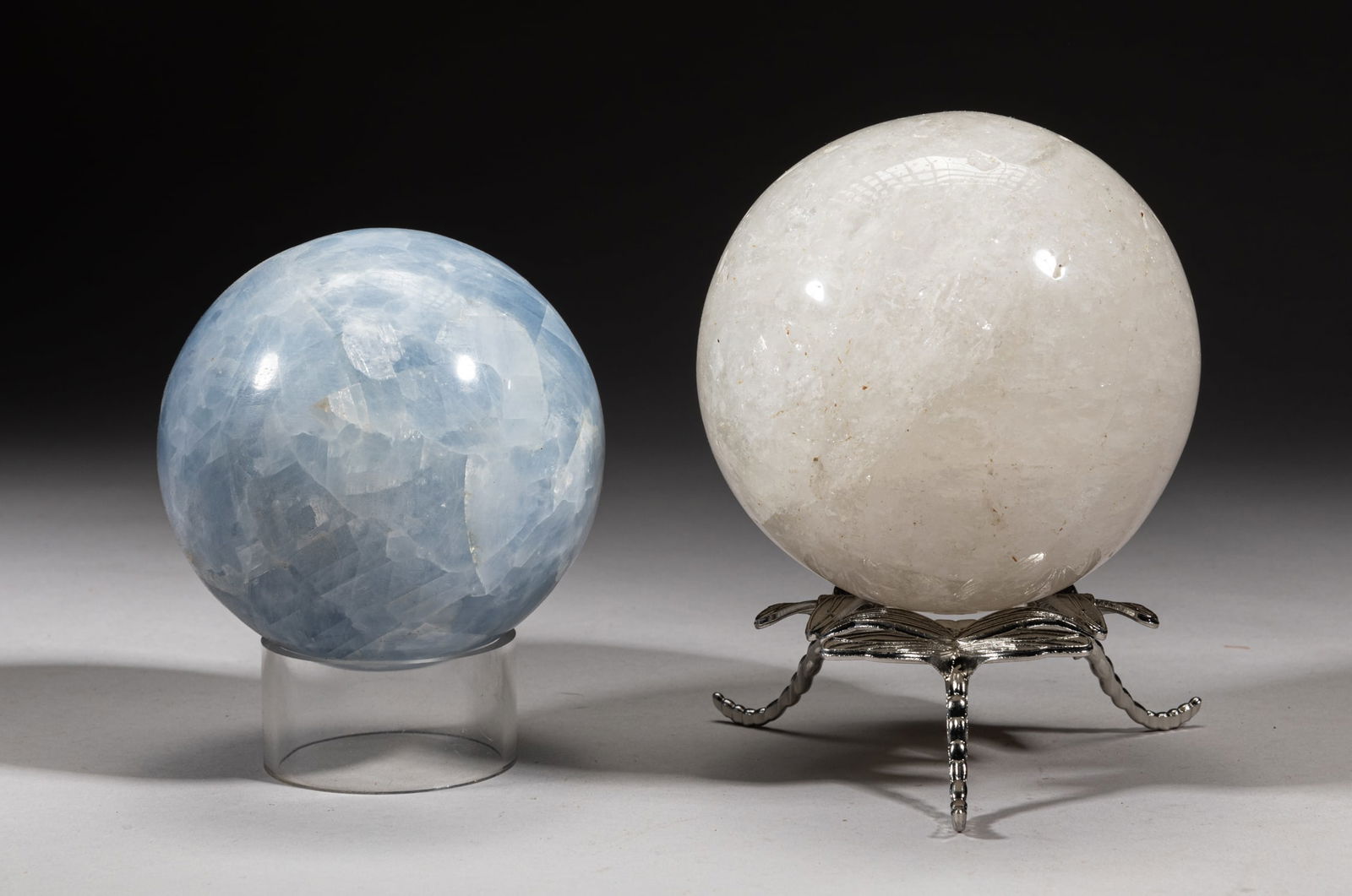 Rock Crystal & Aquamarine Balls: Including a white rock crystal carved ball with dragonfly form stand, and an aquamarine ball with a circular stand. Approx. 3.75inch D (larger ball).
