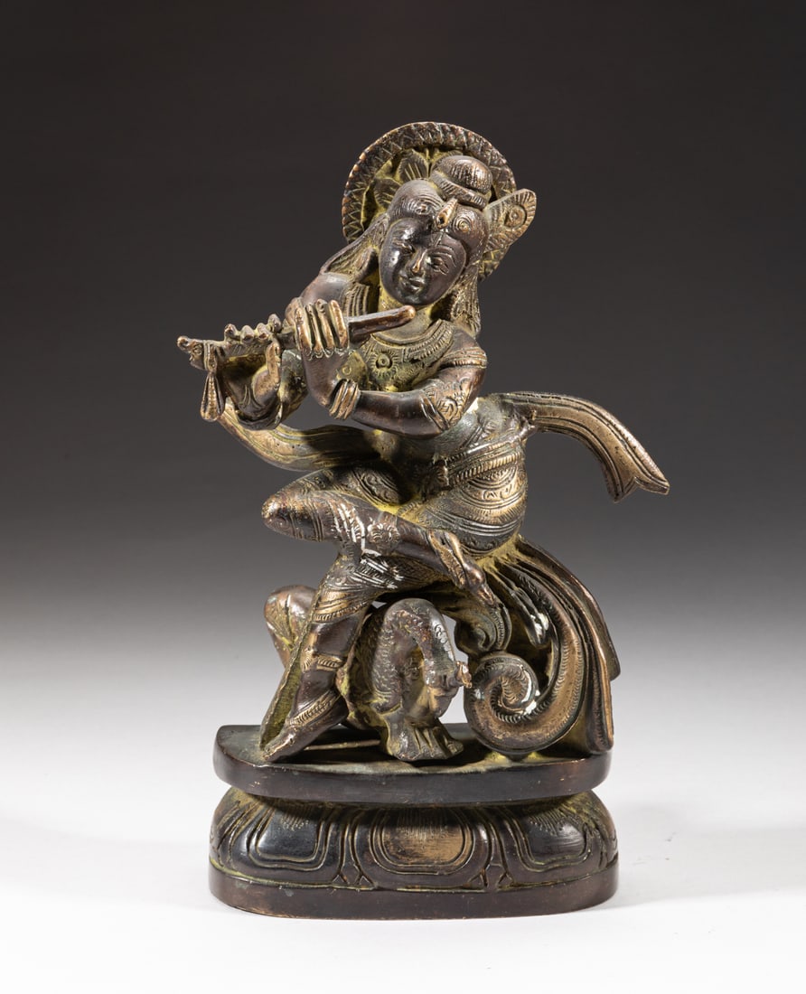 Indian Bronze Sculpture of Buddha: The Buddha cast seated above a lotus base with hands holding an instrument, a beast crouching beneath his legs. Approx. 7.9-4.1-1.8 inch.