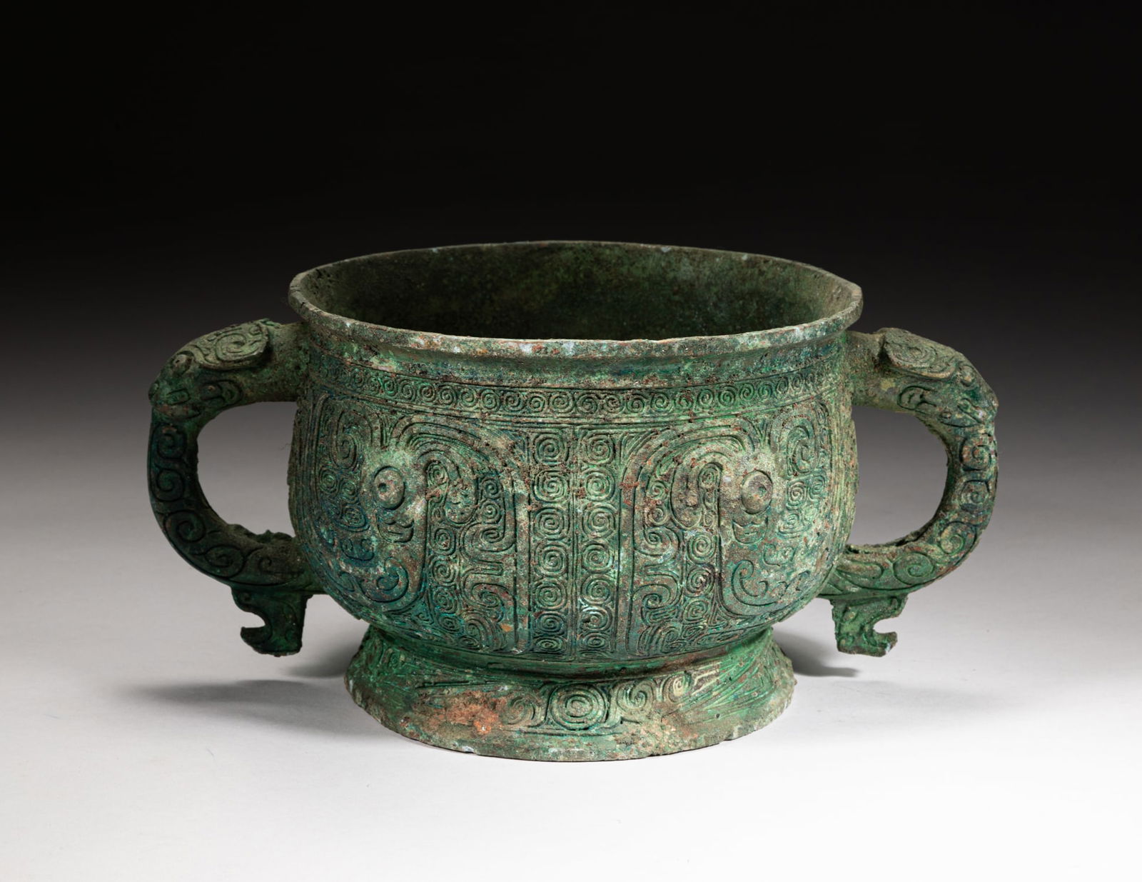 Chinese Bronze Censer w/ Taotie Mask: Of broad U-shaped form with a spreading foot, with two handles issuing from beast heads, the exterior carved with archaistic birds on scroll ground. Approx. 9.7-6.2-4.6 inch. _x000d_