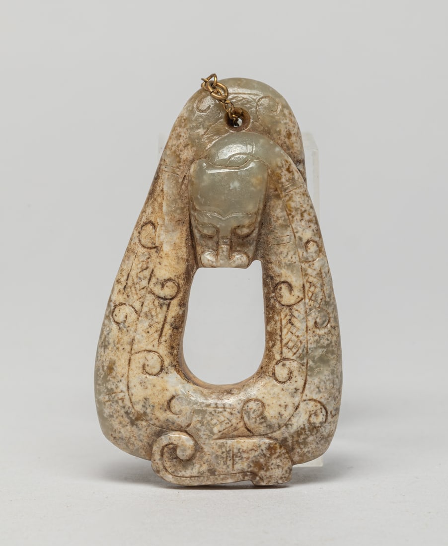 Chinese Russet Jade Pendant of Dragon: Special form Chinese russet jade pendant, carved as a stylized dragon with its body forming in triangular shape, drilled at the tail for suspension. Approx. 2.5-1.5 inch.