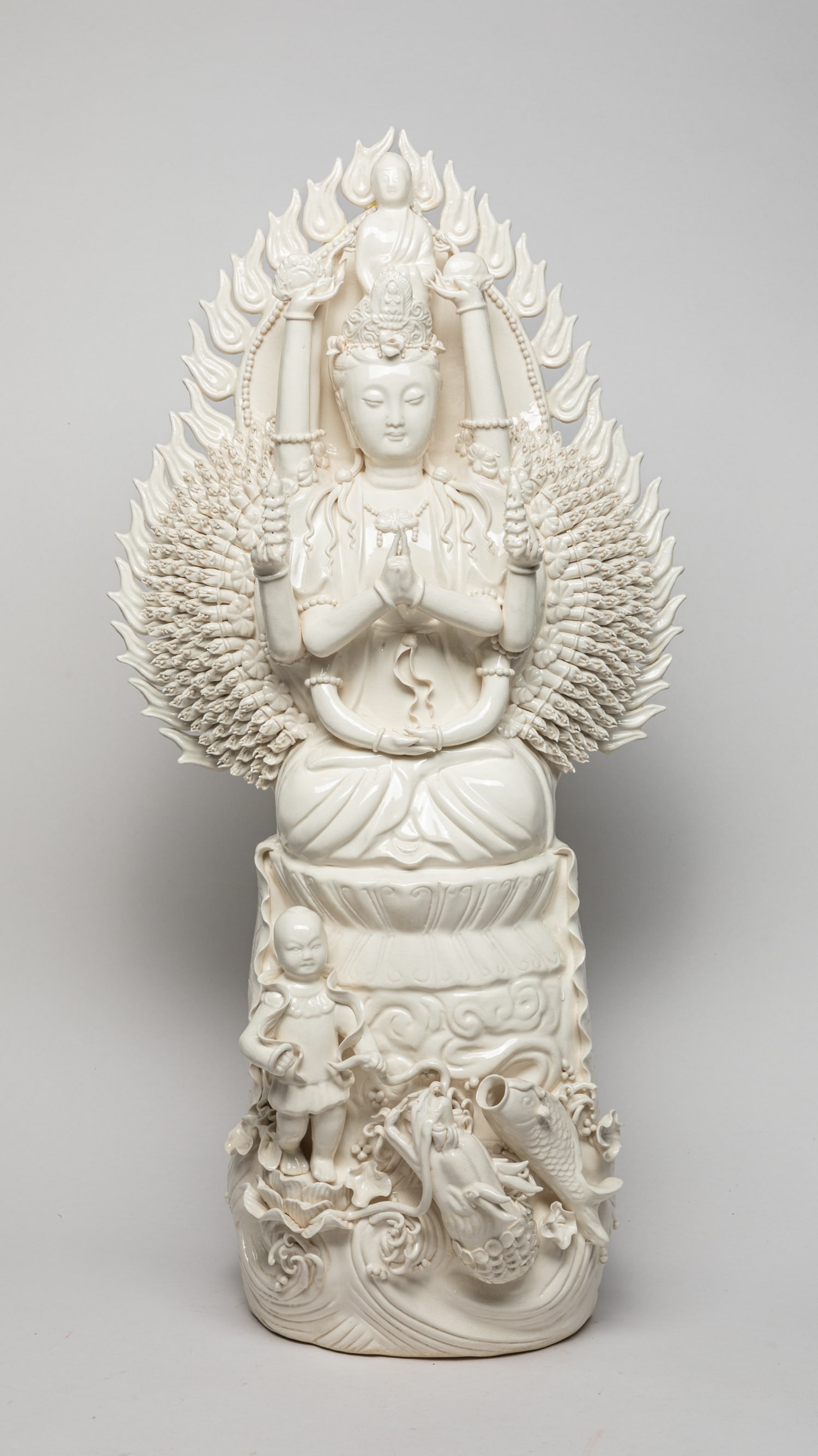 Chinese Tall Blank De Porcelain Figure: Chinese white-glazed porcelain thousand hand Guan Yin sculpture, with boy, dragon and carp around the Guanyin's feet. Approx. 25-12-6 inch.