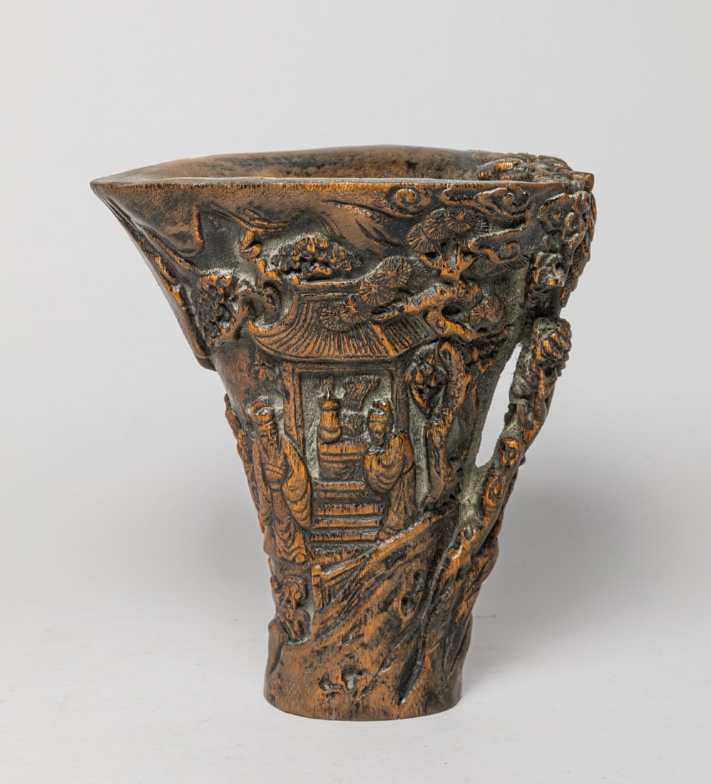 Chinese Bark of Agarwood Cup: The bark of agarwood cup exterior carved in raised relief with figures in various activities in landscape setting, with pine trees and rockery. Approx. 6.6-6-4.5 inch.
