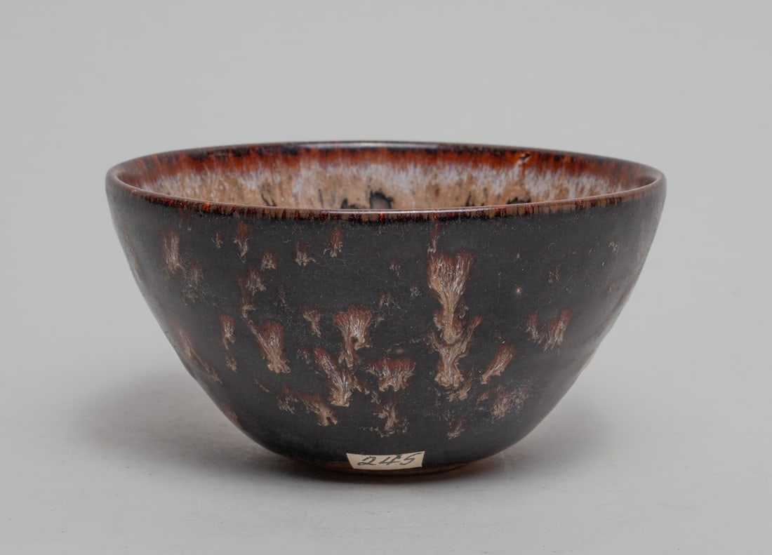 Chinese Jichou Porcelain Tea Bowl: The bowl inside and out covered in black glaze suffused with brown and beige streaks, stopping at the unglazed base. Approx. 4.6-2.4 inch.