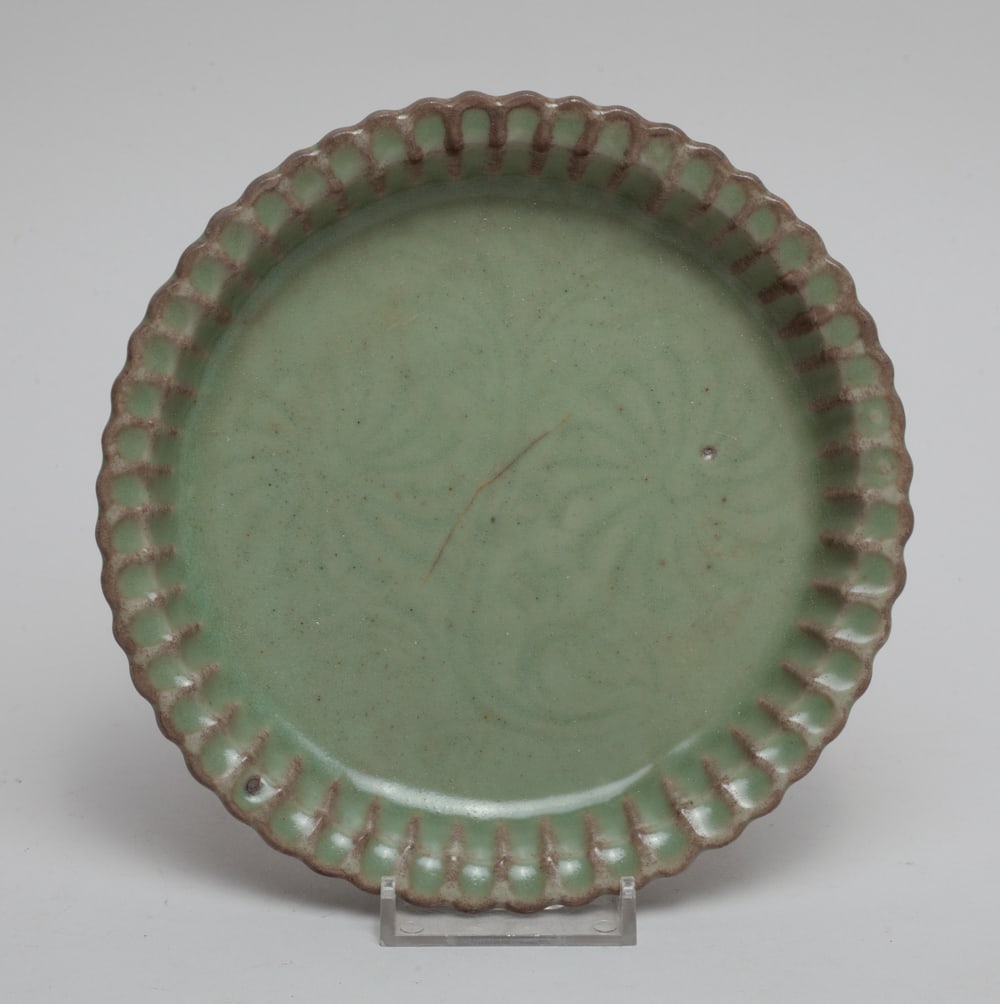 Chinese Longquan Porcelain Lotus Plate: Chinese Longquan porcelain plate with rim carved in lotus form, covered overall in celadon glaze. Approx. 6.3inch W.