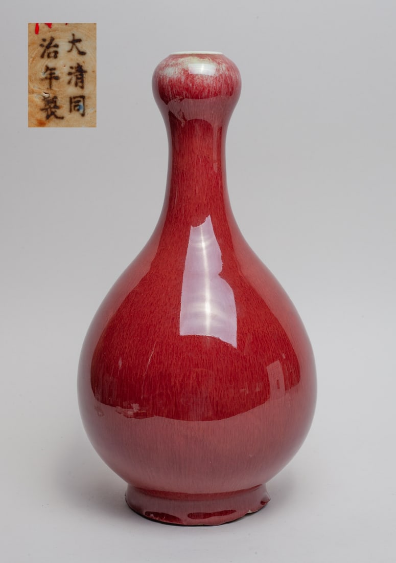 Tall Chinese Flambe Glazed Porcelain Vase: The pear-shaped body rising from a short foot to a waisted neck and garlic mouth, the exterior applied in streaked red glaze, the bottom marked with six characters. Approx. 13.4-7 inch.