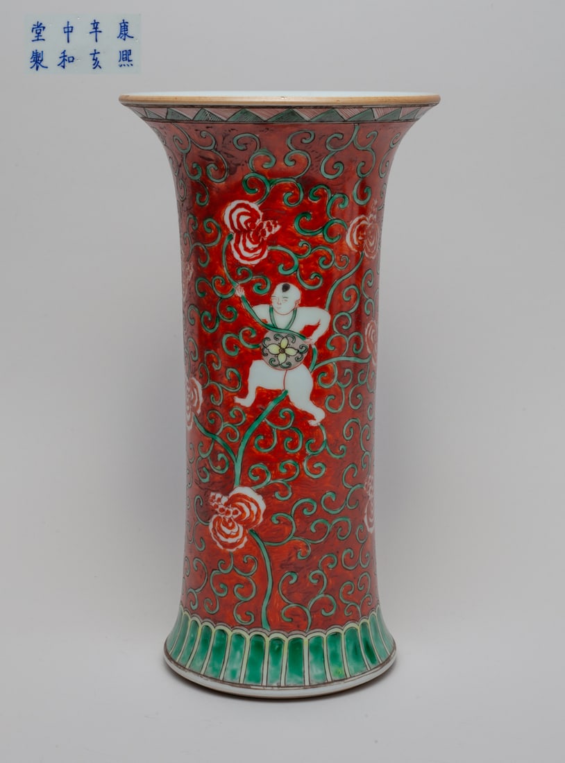 Chinese Famille Rose Porcelain Vase: The cylindrical body with splayed foot and flared rim, the exterior boys holding flower scrolls on red glazed ground, the bottom marked with eight characters. Approx. 11.7-6.2 inch.
