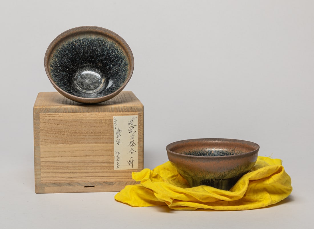 Estate Chinese Jian Porcelain Bowls: Two Chinese Jian ware porcelain bowls covered in black glaze suffused with brown streaks, stopping at the unglazed foot, with box. Approx. 4.75-2.5 inch (larger).