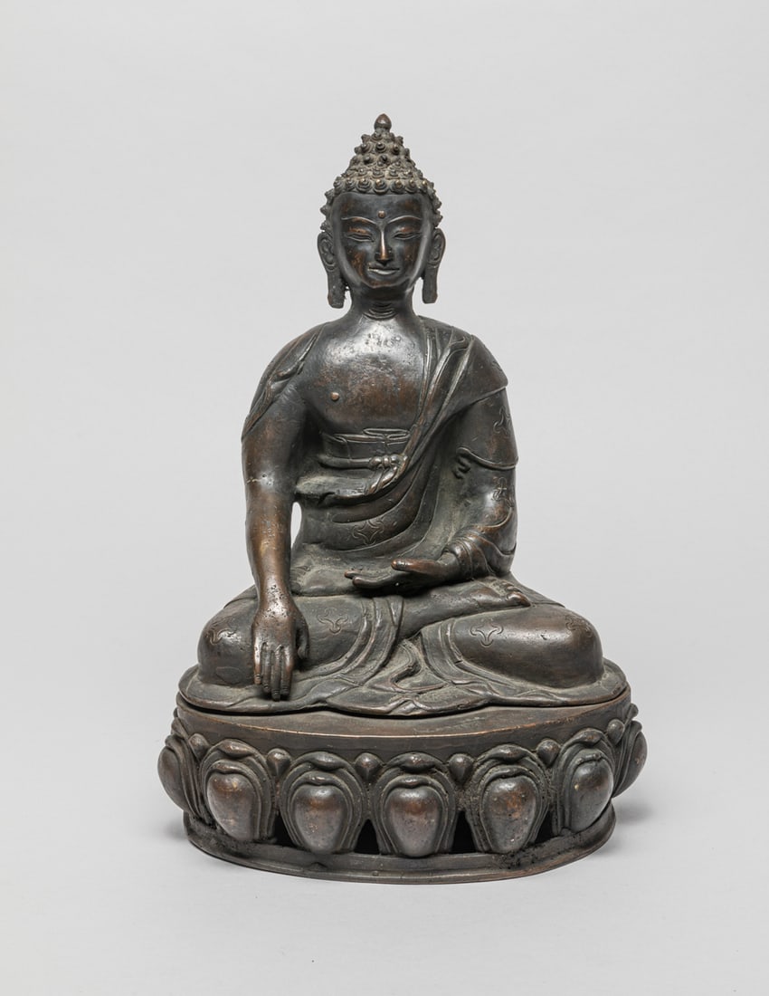 Chinese Sino-Tibetan Bronze Buddha: Chinese Sino-Tibetan hollow bronze Buddha, seated on lotus base, the hands in bhumisparasa mudra, wearing a long loose robe. Approx. 11.4-7.7-5.7 inch.