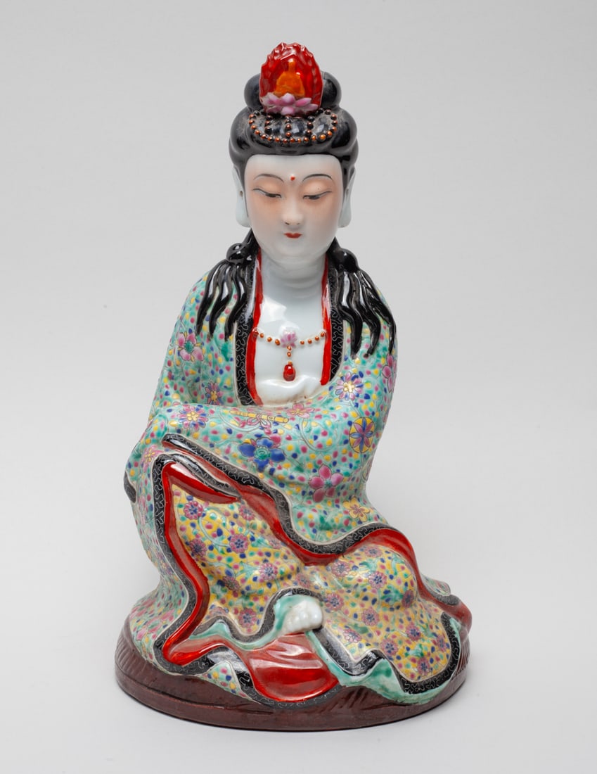Chinese Famille Rose Porcelain Buddha: The porcelain seated Buddha dressed in loose-fitting robe, enameled with flower sprays on traditional symbols on turquoise and yellow ground, carved with seal mark on the bottom. Approx. 10.7-6.1-5.2 