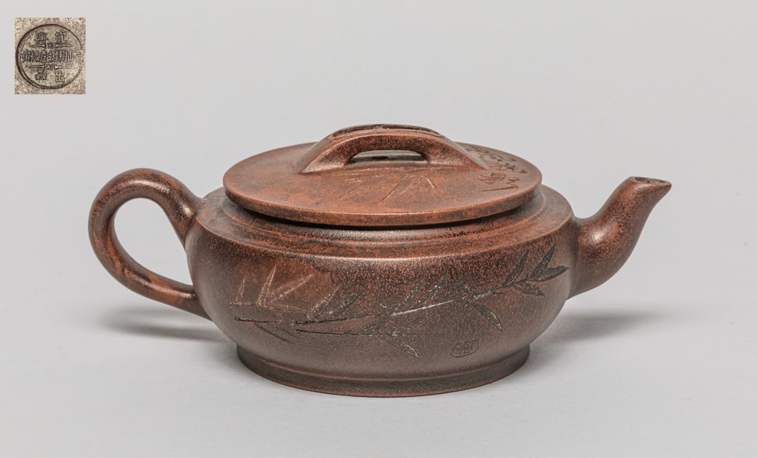 Chinese Carved Zisha Tea Pot: The tea pot exterior carved with bamboo and related poems, the lid interior with a mark and the bottom with a circular mark. Approx. 6.8-4.7-2.8 inch.