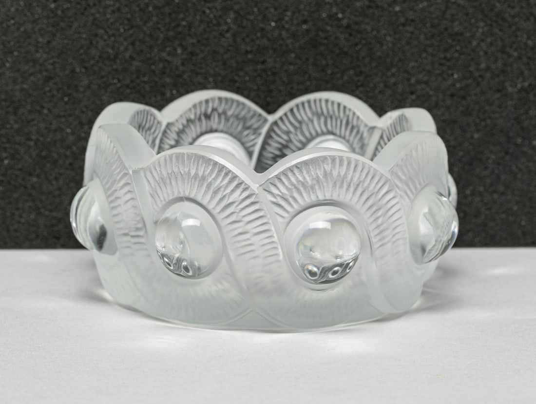 Lalique Crystal Glass Bowl: The crystal bowl cut with two overlapping curved stripes, and a ring of half-balls embedded at each intersection. Approx. 4.2-1.8 inches.