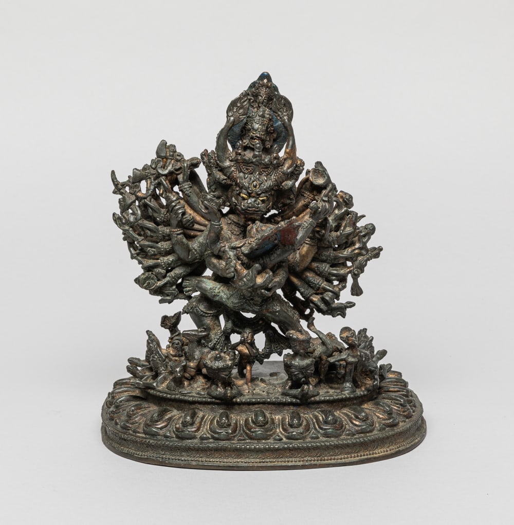 Chinese/Tibetan Painted Metal Buddha: The collectible Yamantaka sculpture, multiple heads facing various directions, multiple hands with different Buddhism instruments, holding a female figure in arms, a separated singular layer lotus bas