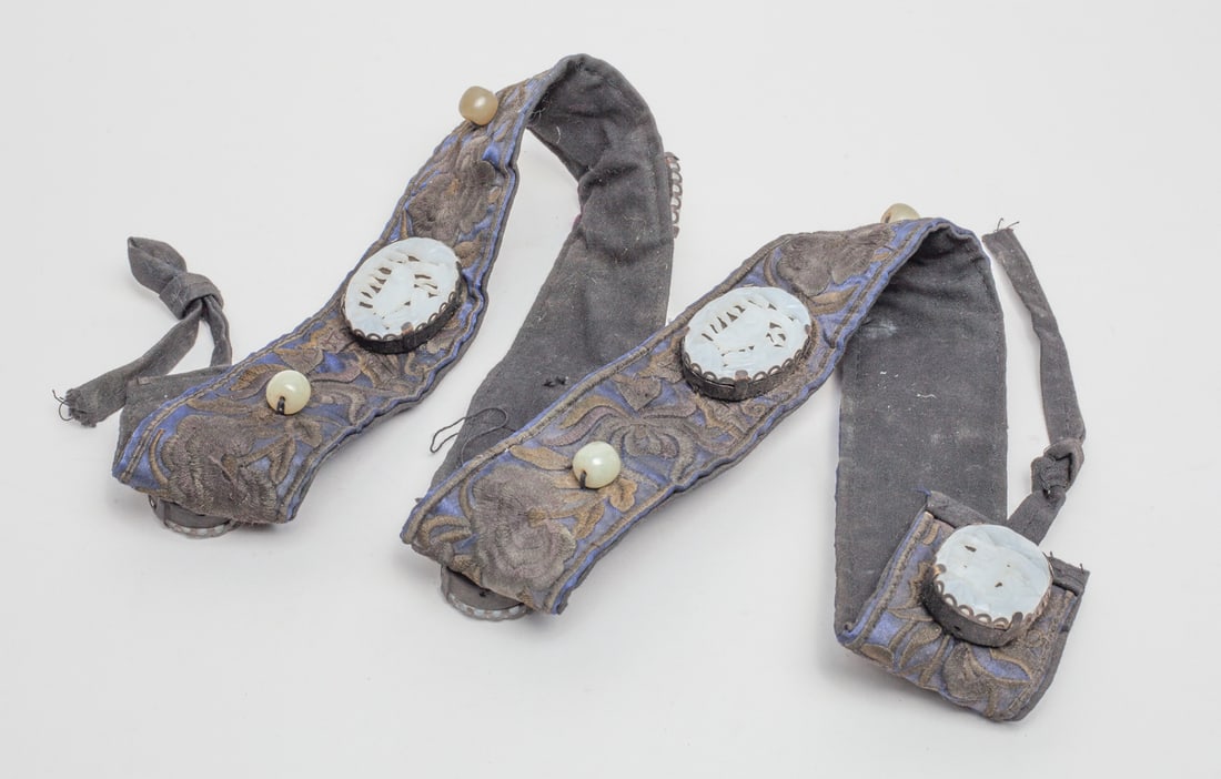 Chinese Jade Belt: The collectible Chinese fabric belt decorated with six jades carved with different flower shape seated in metal cases, with six decor beads. Approx. 43 inches (Length).